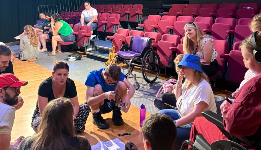 participants sat on the floor taking part in a discussion about the risking it all show